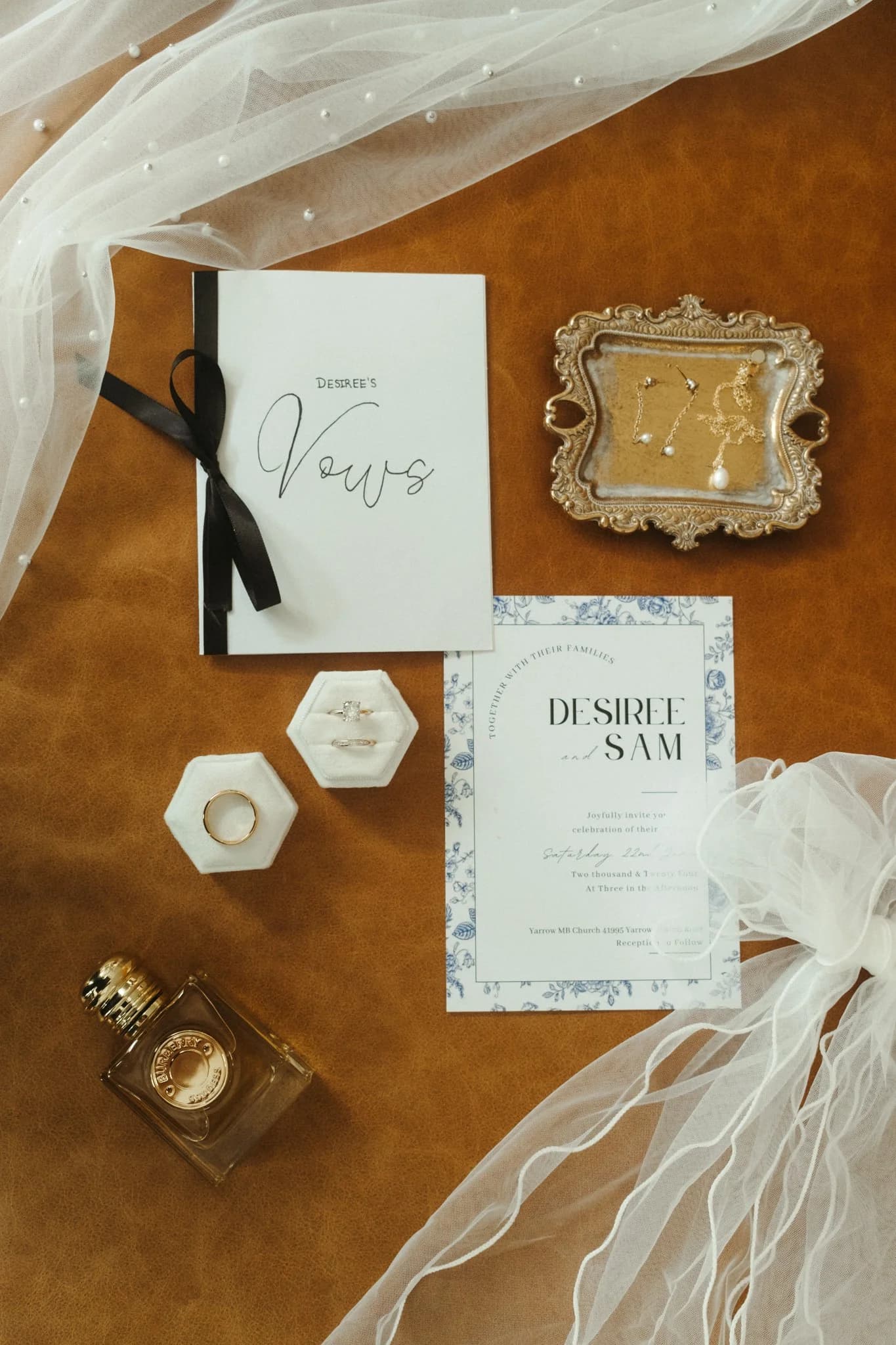 Flatlay of wedding details on warm leather.